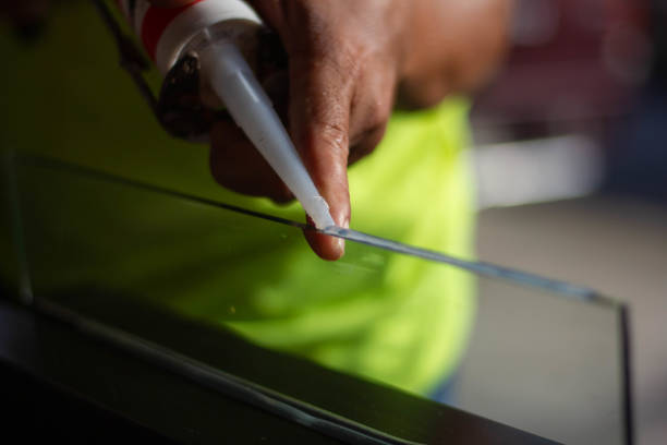 istock The craftsman's hand uses a silicone adhesive 1447557948