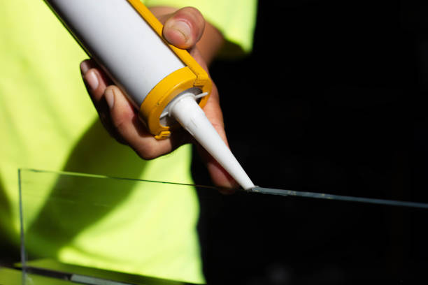 istock The craftsman's hand uses a silicone adhesive 1447557962