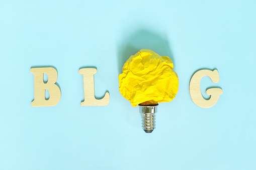 Blog or blogging content creativity, innovative trends and ideas concept. Bright yellow crumpled paper light bulb.