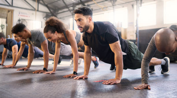 fitness, palestra con uomini e donne che fanno plank, forte ed esercizio per muscoli, cardio e resistenza in classe di allenamento. salute, benessere e diversità, allenamento del corpo e sana sfida attiva. - torso foto e immagini stock