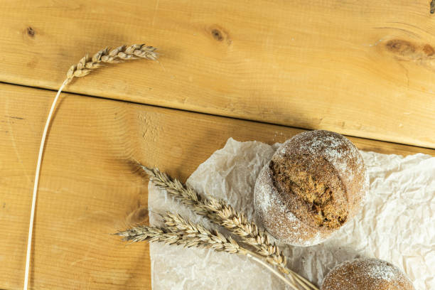 istock Homemade whole-grain sourdough bread, wheat grains and spikelets. Wheat bread spikelets. Spikelets of fresh wheat bread on a brown wooden background. 1447561930