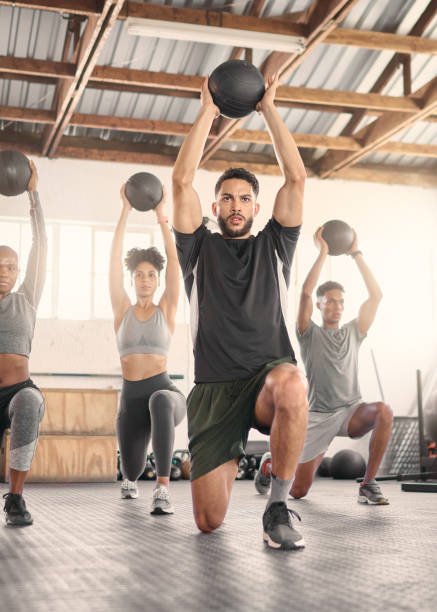 fitness, treinamento e bola medicinal com pessoas em academia e aula para treino, saúde e exercício esportivo. bem-estar, forte e pesos com fisiculturista atleta para músculo, treinamento e resistência - ball indoors lifestyles sport - fotografias e filmes do acervo