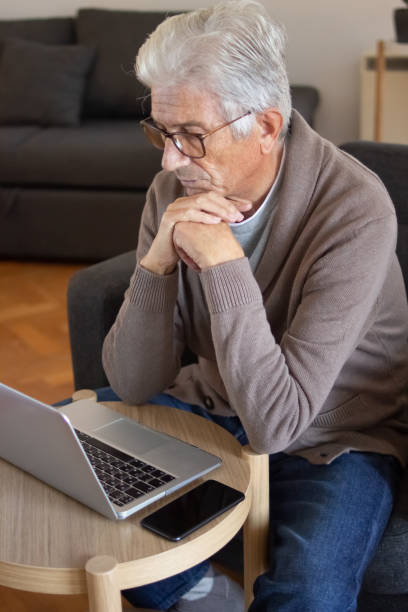 istock Concentrated senior man watching online course 1447564660