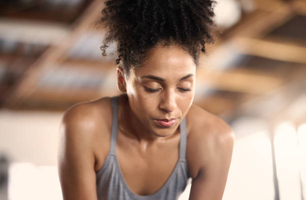 Tired gym woman breathing, challenge and training fatigue, healthy risk and body struggle for sports exercise. Sweating female athlete face, break and rest after workout mindset, focus and breathe gimnasio cansado mujer negra respiración, desafío y fatiga de entrenamiento, riesgo saludable o lucha corporal para el ejercicio deportivo. sudar la cara de la atleta femenina, romper y descansar en la mentalidad de entrenamiento, concentrarse y respirar