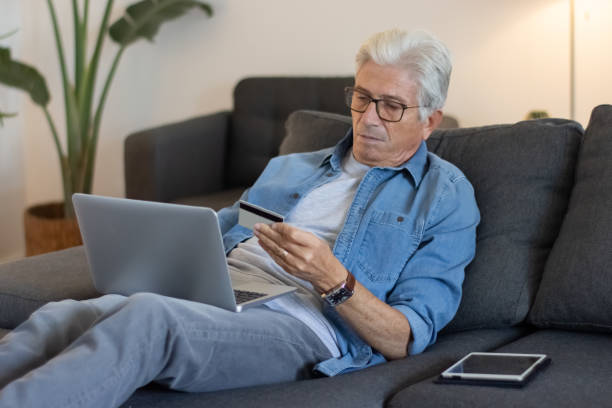 istock Elderly man using credit card for online shopping 1447564882