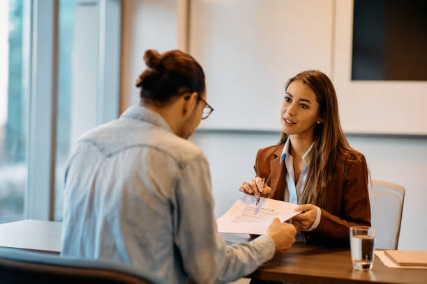 istock Young bank manager going through agreement with her client during a meeting in the office. 1447567019