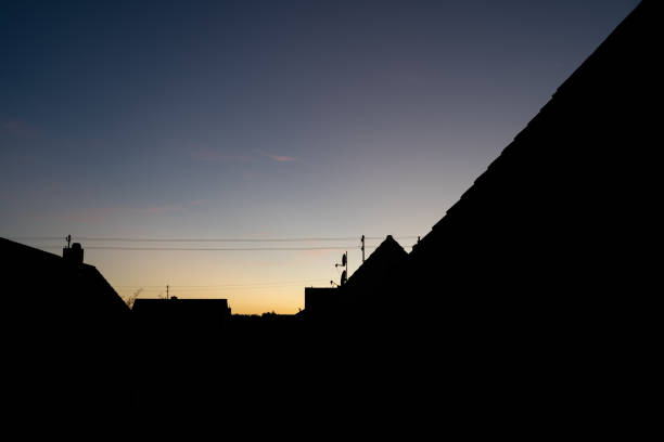 Silhouette of house roofs on a summer evening as the sun goes down