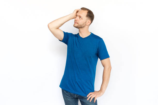 istock Pensive man in T-shirt thinking and scratching head 1447573542