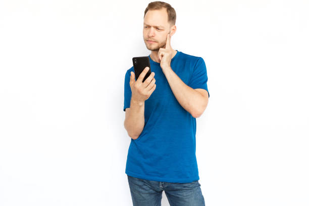 istock Pensive man thinking and holding mobile phone 1447573627