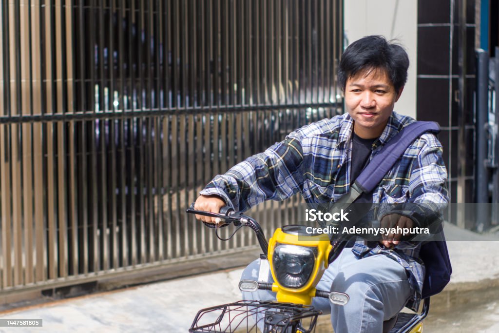 young men riding electric bikes in residential area Electric Vehicle Stock Photo