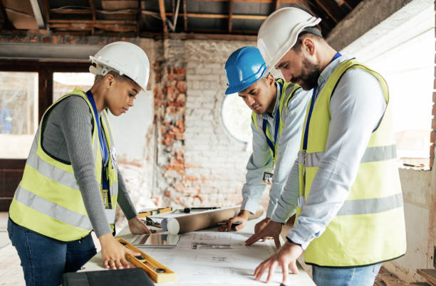 architecte, construction et travail d’équipe avec un ingénieur, un concepteur et un technicien travaillant ensemble sur un plan. réunion, planification et architecture avec une équipe de conception à l’œuvre sur un chantier - entrepreneur en bâtiment photos et images de collection