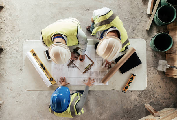 istock Architect, engineer and teamwork with blueprint from above on a building or contractor project. Building, construction team and architecture design sketch with people planning a renovation project 1447581957