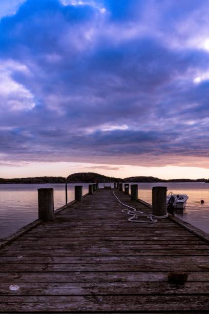 istock Wooden dock against dramatic sunset over a sea, a vertical shot 1447583220