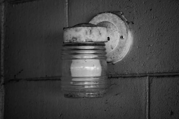istock Grayscale closeup of a rusty wall light at night 1447583254
