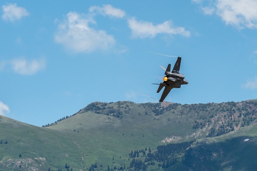 Layton, United States – June 25, 2022: An air force F-35 from a demonstration team performs aerobatics at Hill AFB against Wasatch Mountains