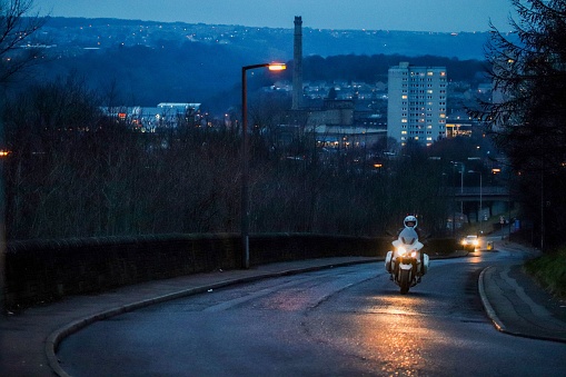 Halifax, United Kingdom – February 18, 2020: A night view of Halifax with a motorcycle coming along in the UK