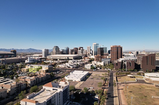 An aerial view of the cityscape on a sunny day with a blue sky in the background