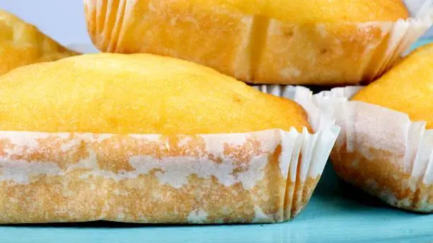 close up of plumcakes on top of blue tray