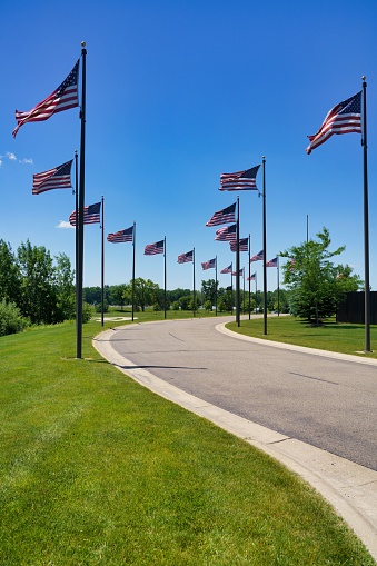 A vertical shot of memorial park surrounded by American flags on flag poles