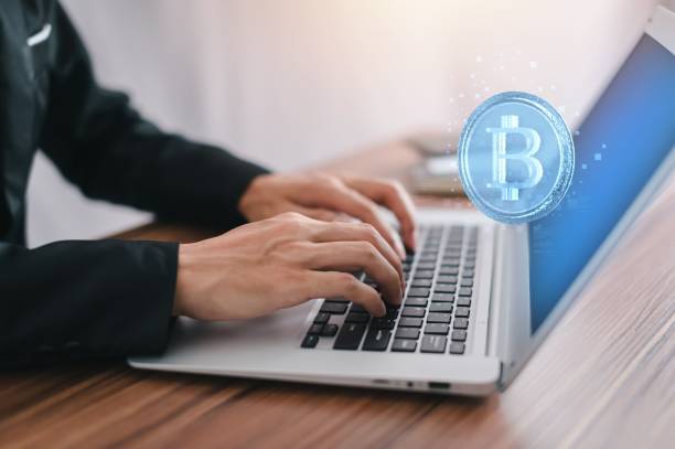 istock Bitcoin symbol and network signs in the air with a hand typing on a computer in the background 1447590376