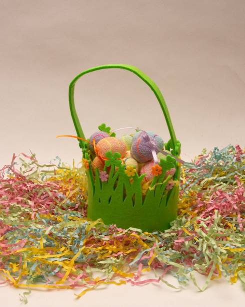 istock Green kids basket with colorful Easter eggs on pastel paper strands 1447590851