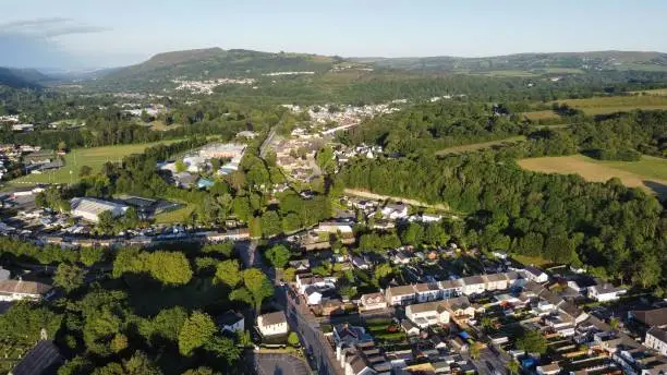 A high-angle shot of a town mountains and fields in the Swansea valleys