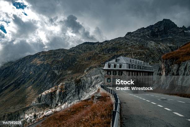Lowangle Of Furka Pass Autumn View With A Building Yellow Grass Mountains Gloomy Sky Background Stock Photo - Download Image Now