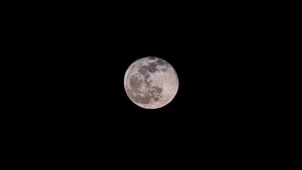 istock Closeup of a full moon illuminated a dark night sky 1447593415