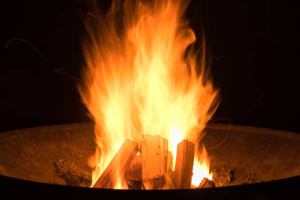 istock Closeup shot of a fire in black round fire pit during nighttime 1447594093
