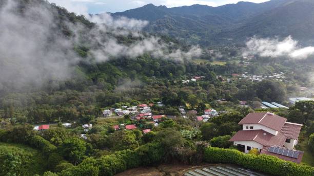 istock High-angle of town trees around forested mountains clouds on 1447595228