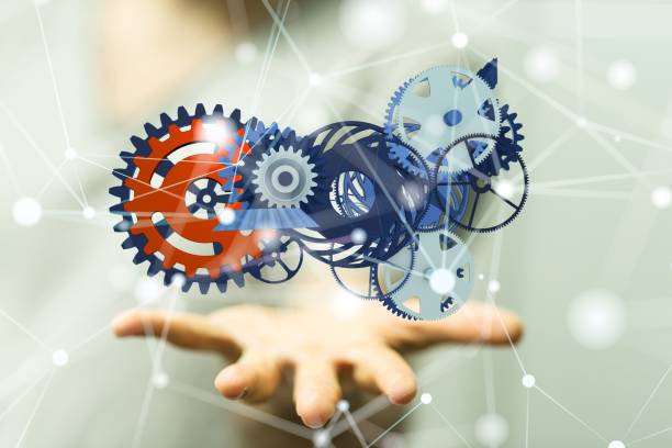 istock Businessman presenting a 3D rendered hologram of a gear system in a cyberspace 1447595701