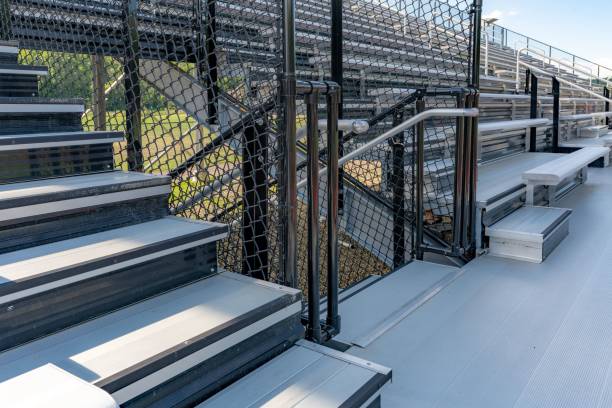 istock Exit, entrance, vomitorium at empty metal stadium bleacher seats along aisle with steps and railing. 1447596309