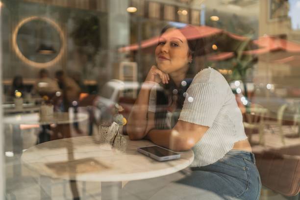 istock Caucasian brunette from Spain sitting in a cafe with reflections on a window 1447598404