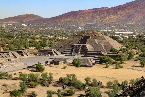 An aerial shot of the Pyramid of the Moon with mountains in the background in Teotihuacan, Mexico