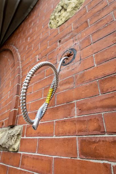 istock Electrical wiring hanging out of old brick building 1447599793