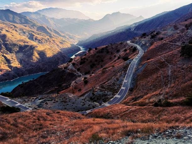 istock Road in canyon with a near river under a cloudy sky 1447601362