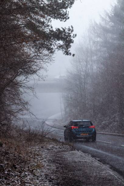 widok ulicy na drogę w skipton z samochodem jeżdżącym po śnieżnej i mglistej pogodzie - drivng zdjęcia i obrazy z banku zdjęć
