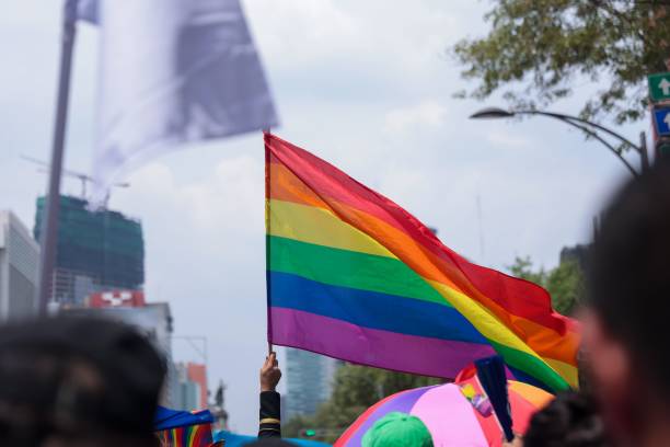 istock People marching and waving rainbow flags as support on Pride day 1447602044