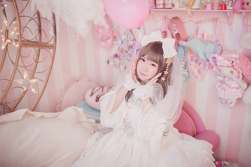 Dark Maiden lolita girl in a white cute dress in a pink childish room