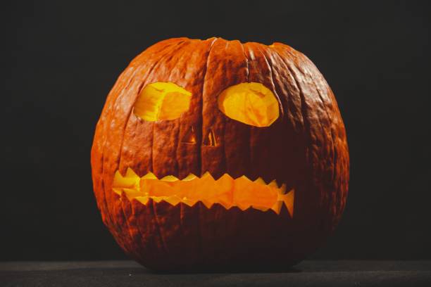 istock Jack-o-lantern made of a pumpkin against black background 1447604540