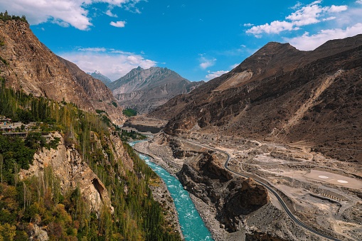 An aerial shot of the Hunza River surrounded by mountains on a sunny day