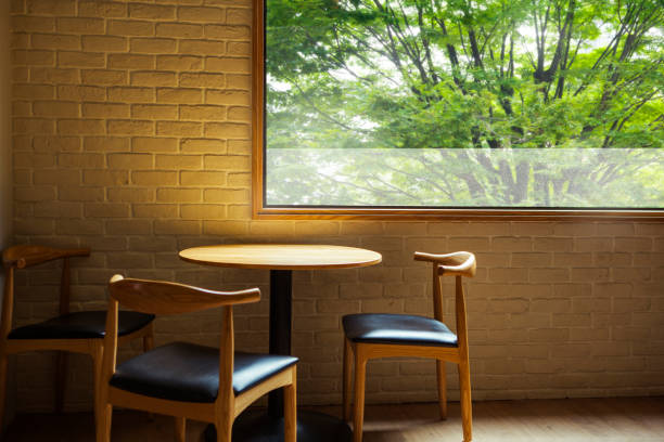 Empty stool chairs at a window table for coworking at a modern office space, decorated in a vintage style.