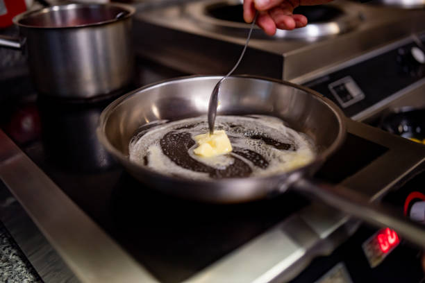 chef frying butter in pan at kitchen - margarine dairy product butter close up imagens e fotografias de stock