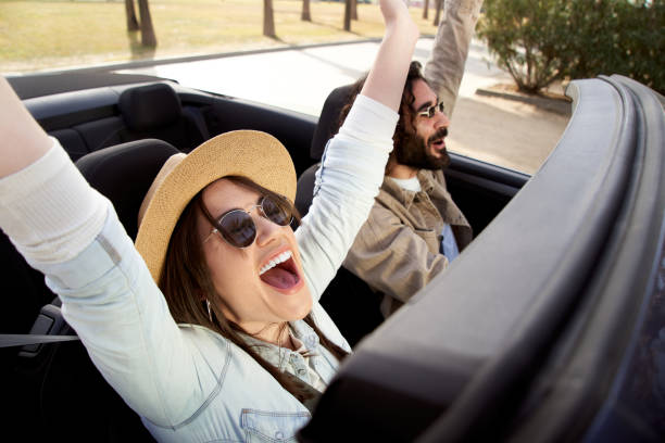 szczęśliwa para przyjaciół lubiąca tańczyć w samochodzie siedząc na przednim siedzeniu i dobrze się bawiąc podczas podróży - road trip audio zdjęcia i obrazy z banku zdjęć