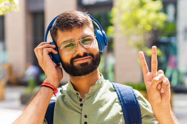 istock indian student with blue headset and backpack well looking at sunny day 1447616571