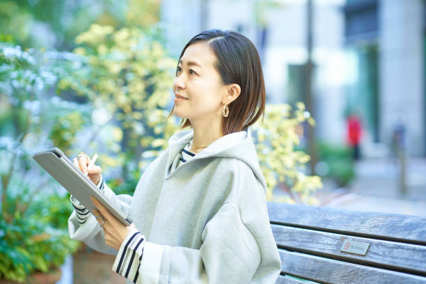 istock A woman in casual clothes operating a tablet PC 1447616706