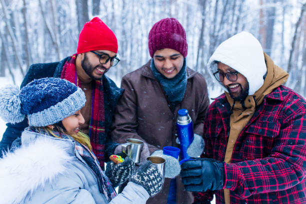 istock Happy young indian friends get warming with hot tea 1447616787