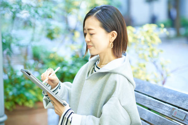 istock A woman in casual clothes operating a tablet PC 1447617157