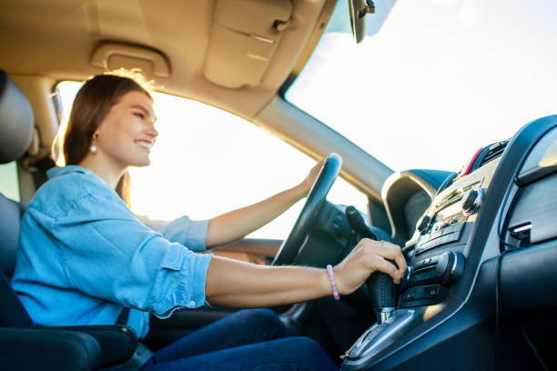pretty woman singing while driving a car on road trip on summer day stock photo