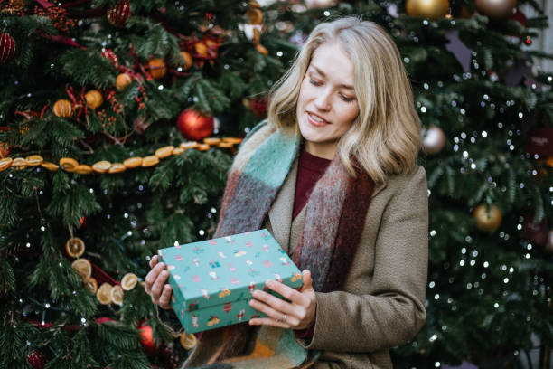 istock Happy Woman Holding a Christmas Present in her Hands 1447620644